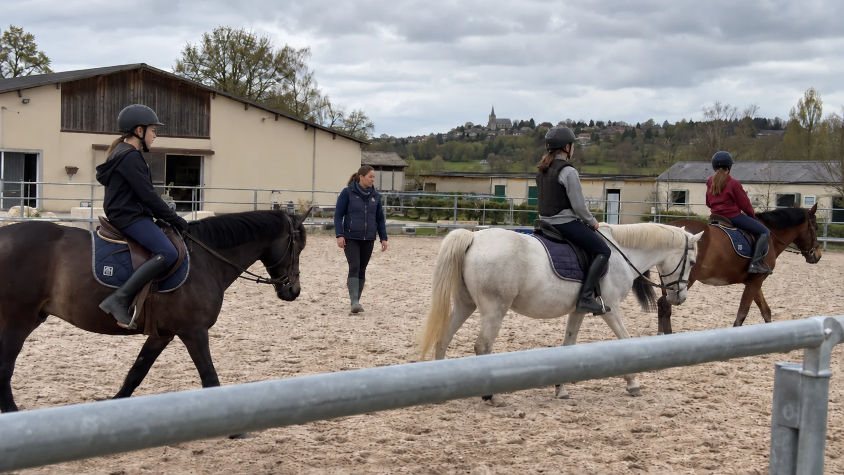 Deux cavalières suivent une reprise avec leur monitrice en carrière